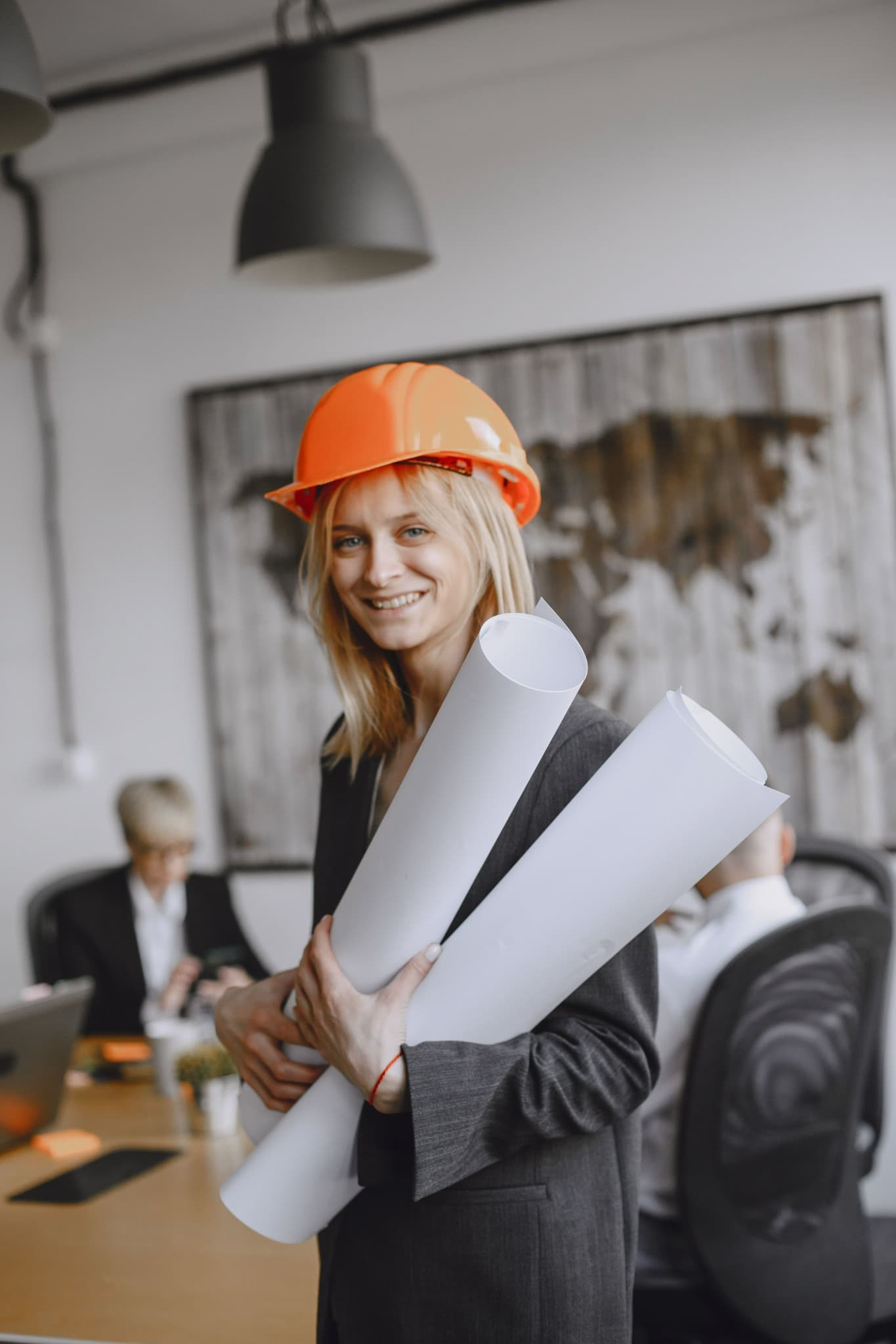 Professional holding building plans and wearing a safety helmet